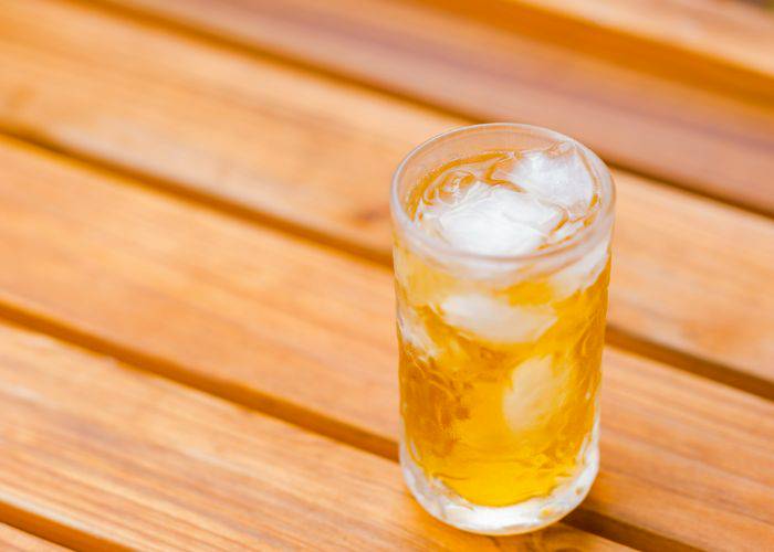 An iced barley tea on a wooden table. It looks bright and refreshing.